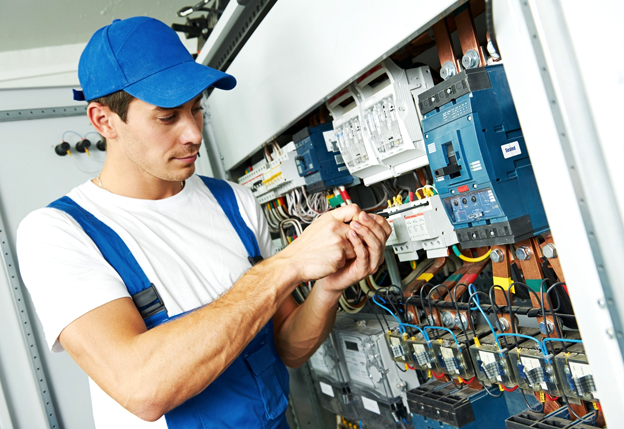 Commercial electrician inspecting and wiring electrical panel in Orlando, FL business