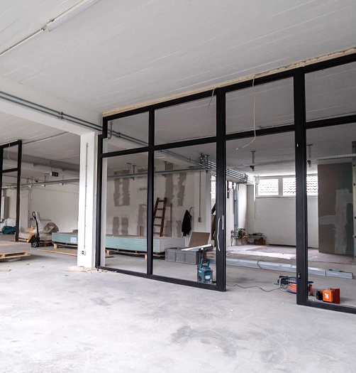 Ongoing commercial remodeling project with black framed glass walls and construction tools by TJ Handyman Services in Orlando, FL