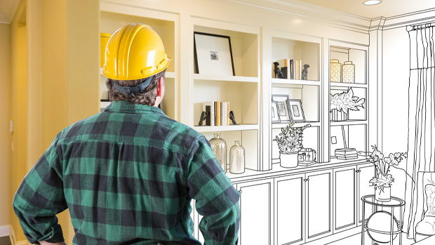 Contractor in yellow hard hat reviewing home remodeling plans with a blueprint sketch overlay in Orlando, FL