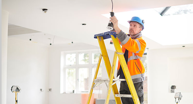 Residential electrician installing ceiling light fixture in Orlando, FL home