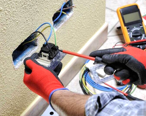 Residential electrician wiring a wall outlet during circuit breaker repair in Orlando, FL