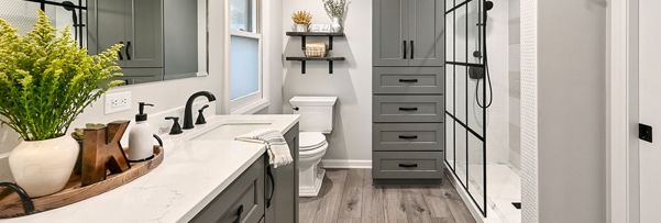 Modern bathroom remodel with gray cabinets, walk-in shower, and white countertop by TJ Handyman Services in Orlando, FL