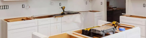 Partially remodeled kitchen with new white cabinets and tools during home renovation in Orlando, FL