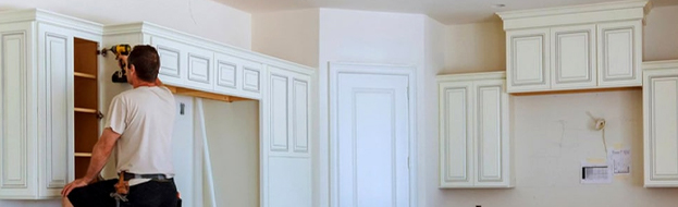 Handyman installing custom white kitchen cabinets during a remodel in Orlando, FL