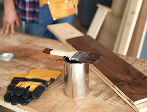 Paintbrush and wood stain on a workbench during a residential painting project in Orlando, FL
