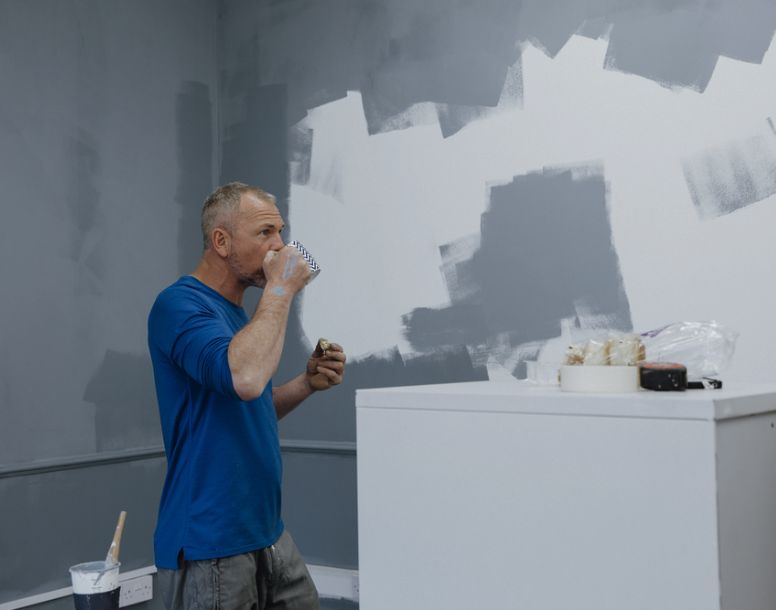 Painter reviewing wall textures and color patterns during interior painting project in Orlando, FL