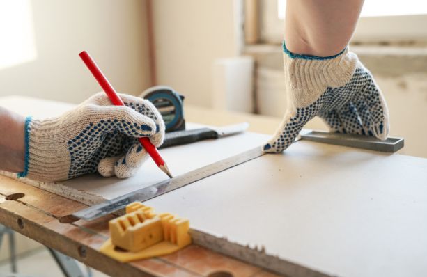 worker measure drywall sheet