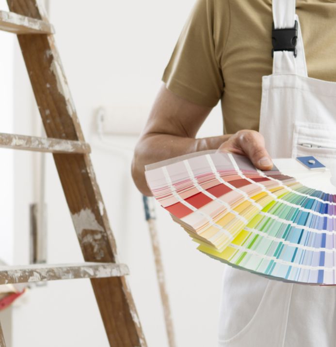 Painter in Winter Park, FL holding a paint color swatch chart during a home consultation