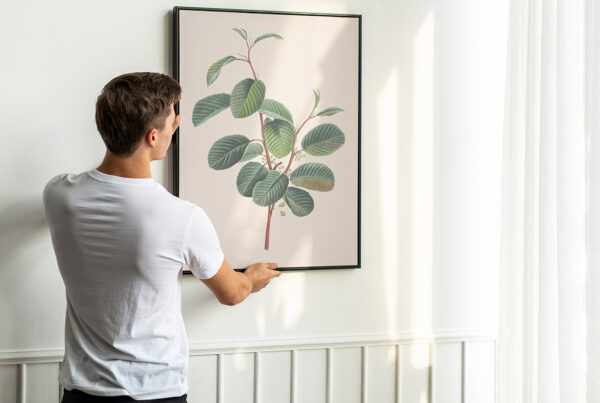 Man hanging framed picture on interior wall during professional picture hanging service in Orlando, FL